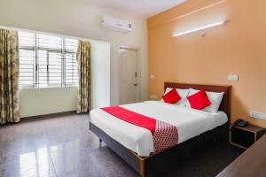 a bedroom with a large bed with red pillows at The Olive Shine in Mysore