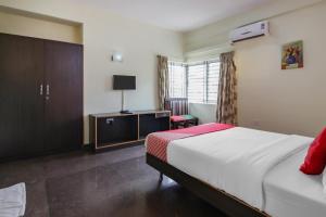 a hotel room with a bed and a tv at The Olive Shine in Mysore