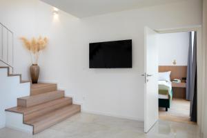 een woonkamer met een trap en een tv aan de muur bij Luxury & stylish Villa Maslina 10 m from the sea in Vela Luka