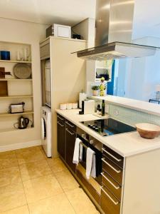 a kitchen with a sink and a stove top oven at Modern, beautiful 1 bed with views -V&A Waterfront in Cape Town