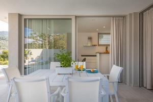 een witte eetkamer met een witte tafel en stoelen bij Luxury & stylish Villa Maslina 10 m from the sea in Vela Luka
