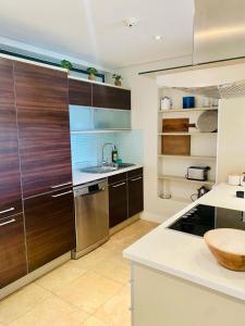 a kitchen with wooden cabinets and a sink at Modern, beautiful 1 bed with views -V&A Waterfront in Cape Town