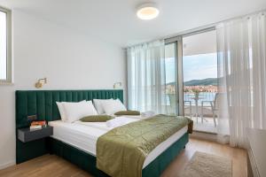 een slaapkamer met een bed en een groot raam bij Luxury & stylish Villa Maslina 10 m from the sea in Vela Luka