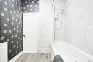 a white bathroom with a tub and a shower at 5 minutes from Leeds City Centre - Parking in Leeds
