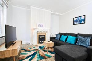 uma sala de estar com um sofá preto e uma lareira em 5 minutes from Leeds City Centre - Parking em Leeds