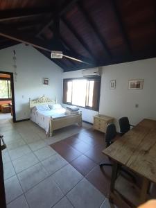 - une chambre avec un lit et une table dans l'établissement Casa Vôo do Beija Flor, à Porto Belo