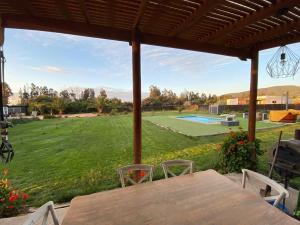 a patio with a table and chairs and a yard at Casa Costa Zapallar in Catapilco