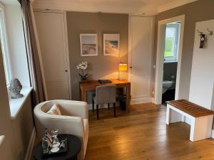 ein Wohnzimmer mit einem Schreibtisch und einem Stuhl in der Unterkunft Hotel und Landhaus 'Kastanie' in Hamburg
