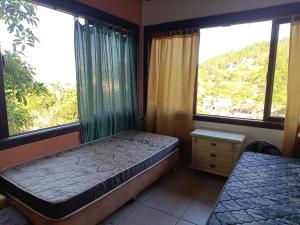 - une chambre avec 2 lits et 2 fenêtres dans l'établissement Casa Vôo do Beija Flor, à Porto Belo