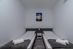 two beds in a room with a white wall at PARADISE RELAX APARTMENT in Bansko +51 photos