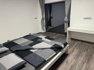 a bed with a black and white comforter in a room at Luxury VIP Villa 230m2+Pool 37m2 in Nové Jirny