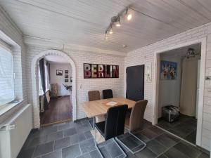 a dining room with a wooden table and chairs at Ferienwohnung Villa Totti Annas Stube in Neßmersiel +7 photos