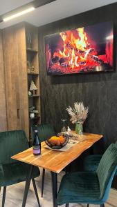 a dining room table with a fire on the wall at Апартамент - Боровец Хотел ''Боровец Гардънс'' A 44 in Borovets +32 photos