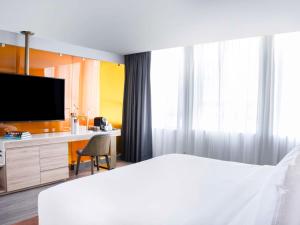 1 dormitorio con 1 cama, escritorio y TV en Mondrian Mexico City Condesa, en Ciudad de México