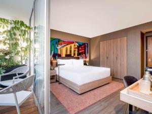 ein Schlafzimmer mit einem Bett und einem Wandgemälde in der Unterkunft Mondrian Mexico City Condesa in Mexiko-Stadt