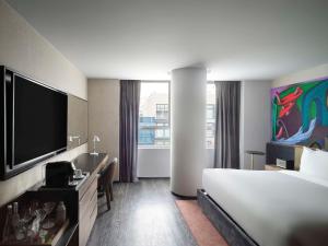 a hotel room with a bed and a flat screen tv at Mondrian Mexico City Condesa in Mexico City