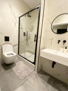 a bathroom with a shower and a toilet and a sink at Goodwin St in London