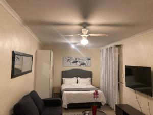 a bedroom with a bed and a ceiling fan at Edenvale corner in Edenvale