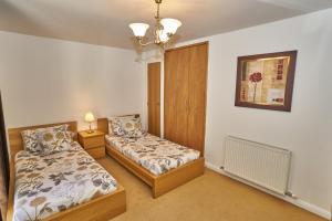 a bedroom with two beds and a picture on the wall at Fountainbridge Residence in Edinburgh