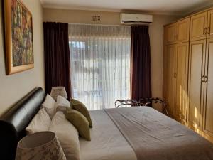Un dormitorio con una cama grande y una ventana en Ringwood Villa, en Ciudad del Cabo