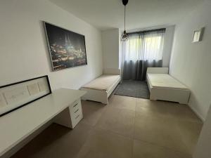 Dieses weiße Zimmer verfügt über 2 Betten und einen Schreibtisch. in der Unterkunft Siegduo in Siegburg