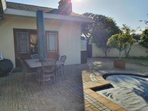a patio with a table and chairs next to a house at Ringwood Villa in Cape Town