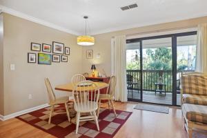 a dining room with a table and chairs and a balcony at 125 Cordillo Parkway in Hilton Head Island