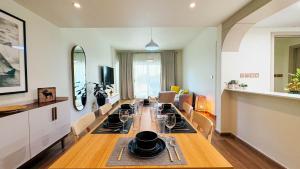 a living room with a long table with chairs and a dining room at Tranquil 1BR Garden Retreat Dubai Greens in Dubai