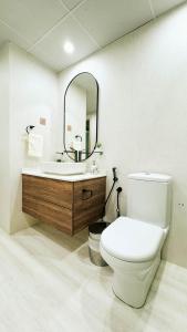y baño con aseo, lavabo y espejo. en Tranquil 1BR Garden Retreat Dubai Greens, en Dubái