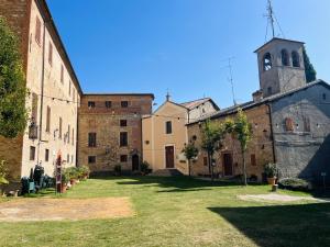 a group of buildings with a clock tower in a yard at B&B LE AMARENE in Sassuolo