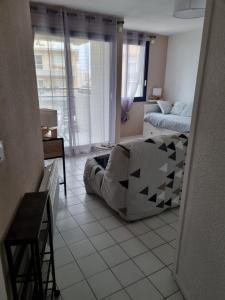 uma sala de estar com um sofá e uma cama em Studio cosy vue mer Canet Plage 3étoiles em Canet-en-Roussillon