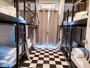a room with bunk beds and a checkered floor at Matcha House jomtien Pattaya in Jomtien Beach