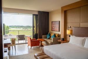 a hotel room with a bed and a living room at VOGO Abu Dhabi Golf Resort & Spa Formerly The Westin Abu Dhabi Golf Resort & Spa in Abu Dhabi