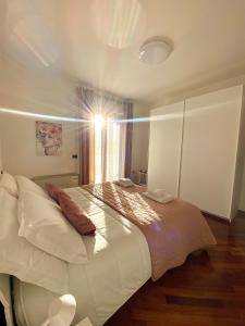 Schlafzimmer mit einem großen weißen Bett und einem Fenster in der Unterkunft Benni House in Civitavecchia