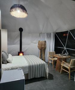 a bedroom with a bed and a table in a tent at River Glamping Kalopanayiotis in Kalopanayiotis