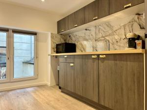 una cocina con armarios de madera y una gran ventana en Suite Maël - Check in h24 - Wifi, en Lyon 20 fotos más