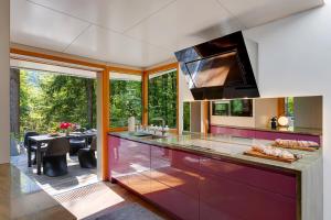 a kitchen with purple cabinets and a dining room at Jasna Mansion in Kranjska Gora