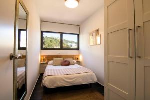um pequeno quarto com uma cama e uma janela em SeaHomes Vacations - ACACIAS Beach&Chic em Lloret de Mar