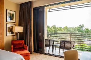 um quarto de hotel com vista para uma varanda em VOGO Abu Dhabi Golf Resort & Spa Formerly The Westin Abu Dhabi Golf Resort & Spa em Abu Dhabi