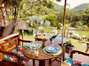 a table on a deck with a view of the water at Estação Serramar in Lumiar