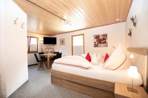 a bedroom with a large bed with red and white pillows at Hotel Restaurant Amadeus in Bad Hindelang