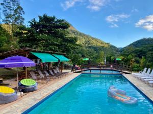 a pool at a resort with mountains in the background at Estação Serramar in Lumiar