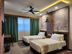 Kampong Kundassan的住宿－基納巴盧山度假村，酒店客房配有两张床和吊扇。