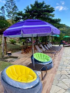 grupa krzeseł i parasol na patio w obiekcie Estação Serramar w mieście Lumiar