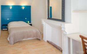 Cette chambre comprend un lit et un miroir mural. dans l'établissement RÉF 398 - HENNEBONT maison de ville de caractère avec jardinet et patio, à Hennebont