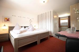 a bedroom with a bed with pillows and a table at Hotel Restaurant Amadeus in Bad Hindelang