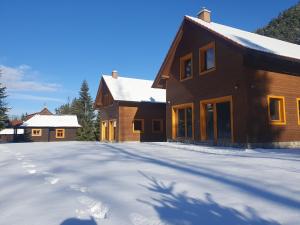dom ze śniegiem na ziemi przed nim w obiekcie Chaty Hana w Demianowskiej Dolinie
