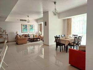 a living room and dining room with a table and chairs at Sea View Cozy 2BHK Al Reem 6ppl - more than 10 days stay free transportation from Abu Dhabi Airport- in Abu Dhabi