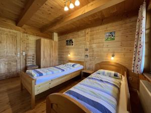 a bedroom with two beds in a wooden cabin at Balzenhof in Titisee-Neustadt
