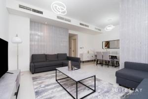 Experience Comfort in Our Charming 3-Bedroom Villa في دبي: غرفة معيشة مع أريكة وطاولة